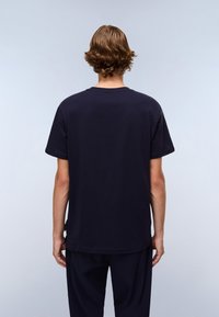 Marineblaue Baumwoll-T-Shirt mit lockerer Passform, kurzen Ärmeln und geripptem Rundhalsausschnitt. Mit einem seitlichen Schlitzdetail am Saum.