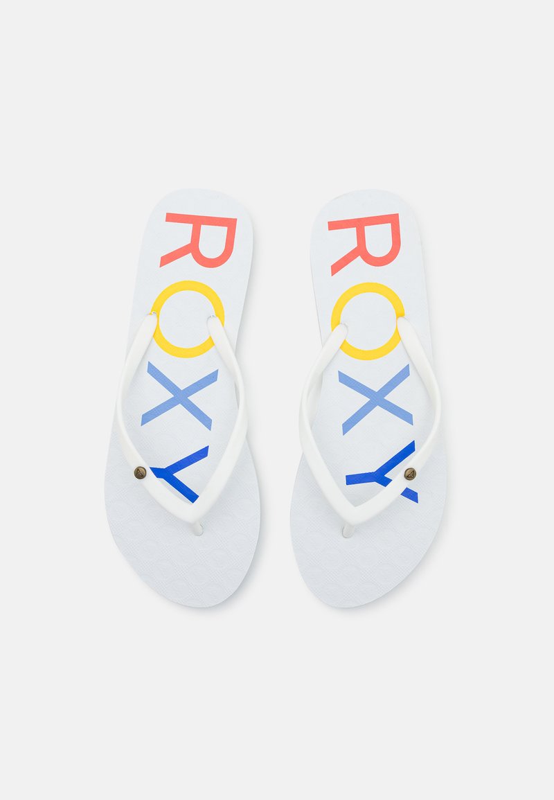 Valged flip-flops tekstuuriga tallaga, millel on mitmevärviline "ROXY" kiri punases, kollases ja sinises. Õhukesed valged rihmad, millel on metalli detail.