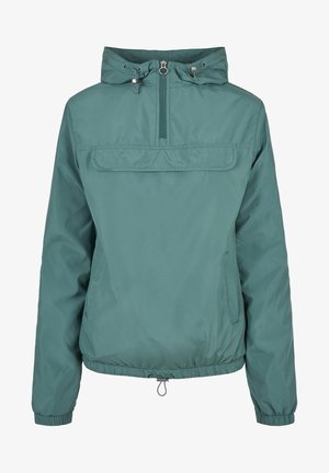 Tealfärgad vindjacka med halvdragkedja, justerbar huva och elastiska ärmslut. Har en framficka och dragsko i nederkanten.