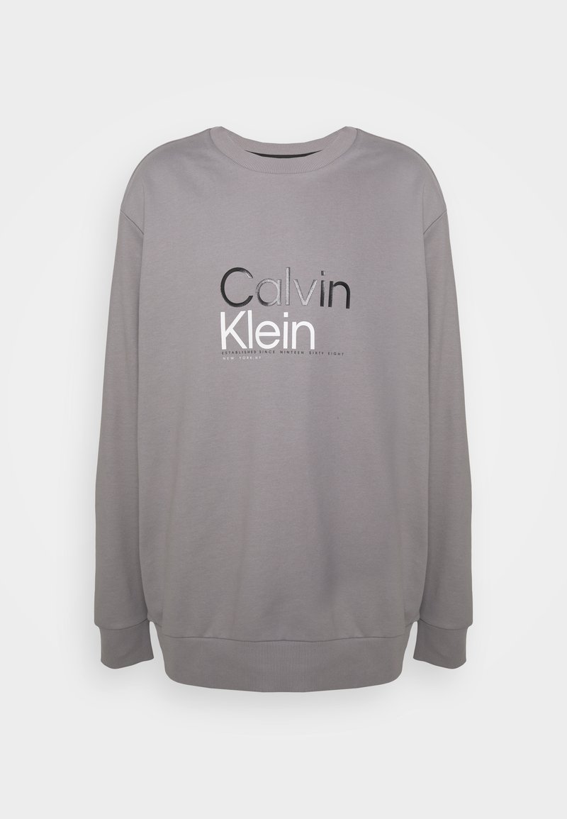 Šedá mikina s kulatým výstřihem, žebrovanými manžetami a lemem. Na přední straně je nápis "Calvin Klein" v kontrastní černé a bílé barvě.