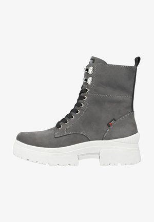 Botín de cuero gris hasta el tobillo con suela de plataforma blanca, cordones negros, ojales metálicos y un acabado texturizado. Presenta una lengüeta en la parte posterior.