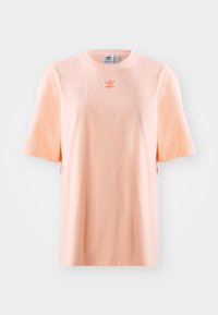 Pfirsichfarbene Baumwoll-T-shirt mit kurzen Ärmeln, Rundhalsausschnitt und kleinem gesticktem Logo auf der Brust. Glatte Textur, lockere Passform.