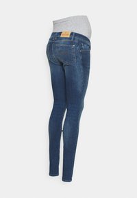 Jeans de maternidade de um azul escuro, com uma faixa elástica cinza, de ajuste justo e design tradicional de cinco bolsos. Apresenta uma etiqueta de couro na parte de trás.