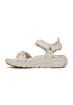 Sandali bianchi con fasce testurizzate, chiusure velcro regolabili e una suola spessa e imbottita. Presentano una suola in gomma con design antiscivolo.