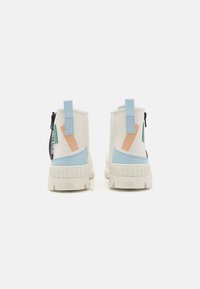 Bottines en toile blanches avec des accents bleus et pêche, dotées d'une fermeture éclair latérale noire et d'une semelle en caoutchouc texturée avec un design rainuré.
