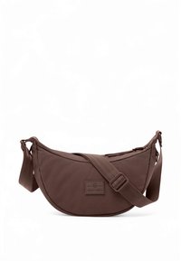 Brown fabric sling bag with a curved shape, adjustable strap, zip closure, and an embossed logo on the front. Smooth texture.