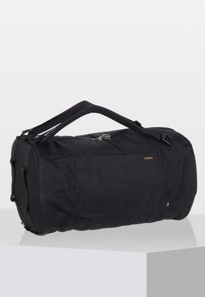 Black duffel bag made of durable fabric, cylindrical shape, zip closure, two top handles, and side pocket with a subtle logo detail.