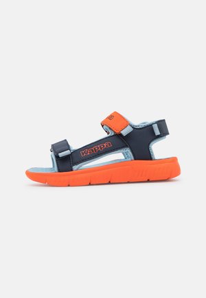Sandalia Kappa azul y naranja con correas ajustables y suela gruesa naranja vista de lado sobre fondo liso.