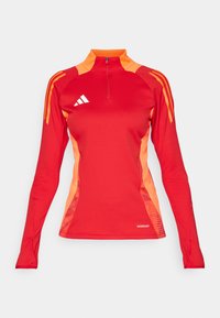 Rotes sportliches Langarmoberteil mit einem Viertel-Reißverschluss, das orangefarbene Akzente an den Ärmeln und Seiten aufweist, gefertigt aus einem glatten, dehnbaren Material.