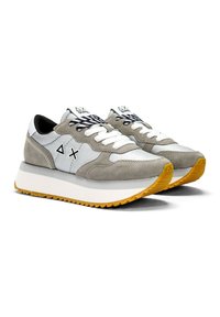 Zapatillas deportivas grises y azul claro con materiales de ante y malla, cordones blancos, suelas gruesas blancas y suelas exteriores amarillas con textura.