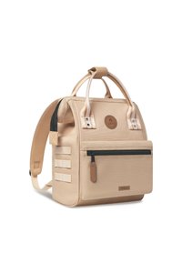 Sac à dos en toile beige avec deux poignées supérieures, des bretelles réglables, une poche zippée à l'avant et un patch logo. Caractéristiques d'accents de bandes verticales.