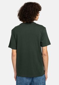 Mørkegrøn bomulds-t-shirt med rund halsudskæring og korte ærmer. Flad syning, uden udsmykning på ryggen, og en afslappet pasform.