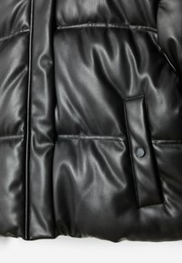 Black padded jacket made of smooth faux leather, featuring a snap pocket detail and prominent quilted texture throughout.