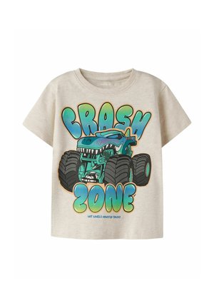 T-shirt beige pour tout-petit avec un monster truck bleu et vert dessin animé et texte en gras "CRASH ZONE" et "Hot Wheels Monster Trucks" en bas.
