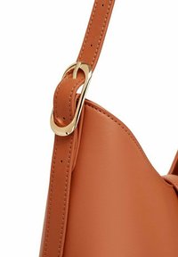 Kabelka z hladké kůže v tan barvě, se zlatým kovovým sponou a popruhem, a se strukturovaným, zakřiveným siluetou.