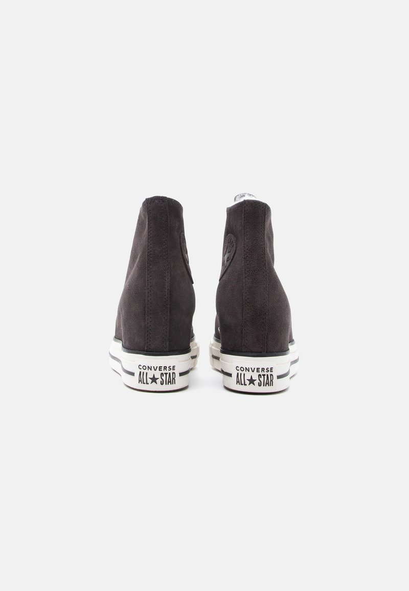 Høje sneakers i kulgrå ruskind med hvide gummisåler. Detaljer inkluderer et logopatch, kontrastsyninger og klassiske designelementer.