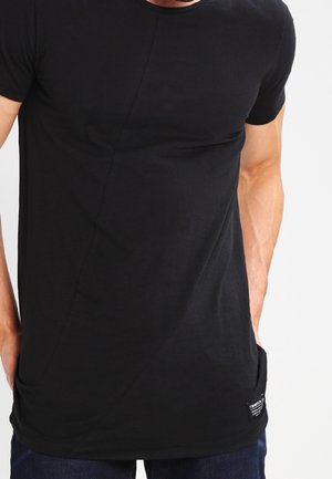 Czarny t-shirt z krótkim rękawem wykonany z miękkiej tkaniny, z zaokrąglonym szwem i małą metką przy brzegu, o dopasowanym kroju.