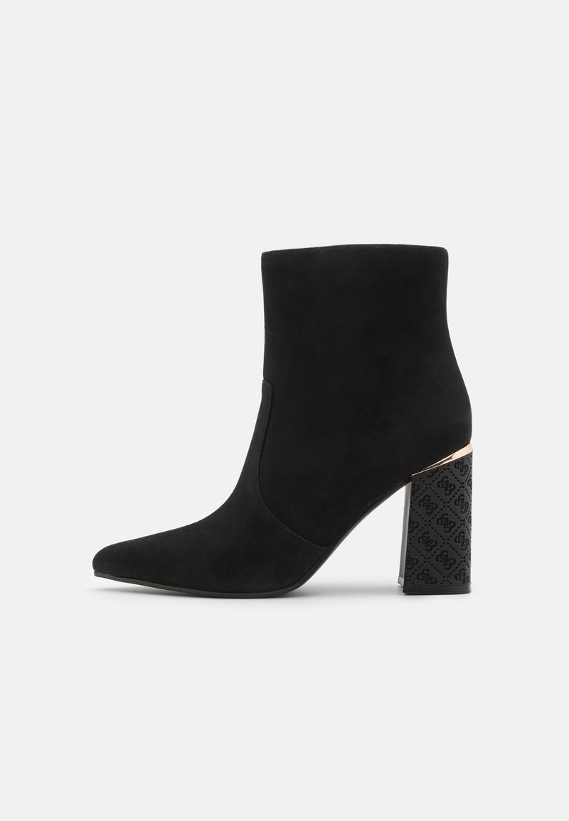 Bottine en daim noire avec un bout pointu et un talon bloc noir texturé présentant un motif décoratif. Fini lisse, design de hauteur intermédiaire.