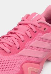 Ροζ αθλητικό παπούτσι με υφασμάτινο επάνω μέρος με υφή, σχεδιασμό με στρώσεις και τρεις διακριτικές λωρίδες, με κλείσιμο με κορδόνια και μαλακή σόλα.