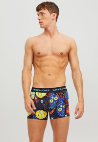 Mehrfarbige Boxershorts mit schwarzem Bund, der das Logo "JACK & JONES" trägt, mit lebhaften Schädel- und Blumenmustern auf einem dunklen Hintergrund.