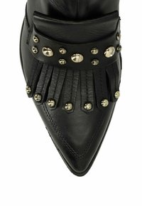 Zwarte leren enkelboot met een spitse neus, voorzien van franjes en zilveren studs op een brede band rond de enkel.