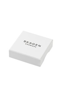 Caja cuadrada blanca con un acabado suave, con el texto "SKAGEN DINAMARCA" en negro en la parte superior. Diseño minimalista, sin patrones o acentos adicionales.