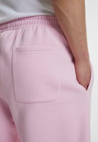 Rosa bomull joggebukser med en baklomme og elastisk midjebånd. Glatt tekstur, med en tettsittende design som fremhever komfort.