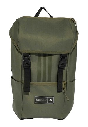 Grüner Stoffrucksack mit oberer Klappe, schwarzen Schnallenriemen, Seitentaschen, vorderer Reißverschlusstasche und Adidas-Logoaufnäher.