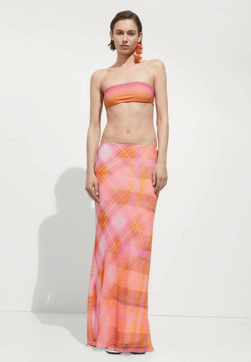 Ensemble deux pièces comprenant un top bandeau sans bretelles rose-orange et une longue jupe fluide avec un motif écossais coloré en rose, orange et marron.