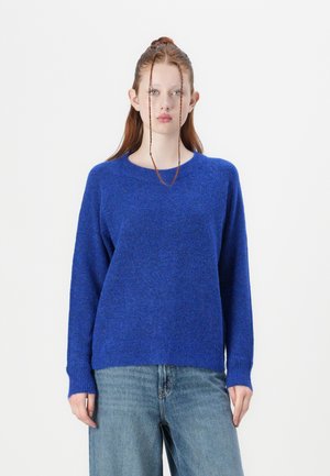 Blue wool sweater with a crew neck, long sleeves, and ribbed cuffs. Paired with light blue wide-leg jeans. Simple, textured design.