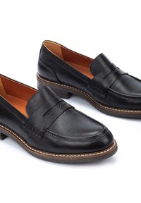 Mocassins en cuir noir à finition lisse, avec une bande décorative et des accents cousus. Semelle en caoutchouc marron avec un léger talon.