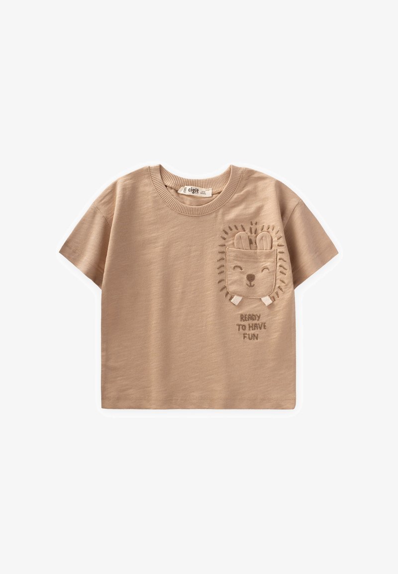 Bežs īsām piedurknēm T-krekls, izgatavots no mīksta kokvilnas auduma ar apaļu izgriezumu. Ar izšūtu lauvas dizainu un uzrakstu "GATAVS JAUTRĪBAI."