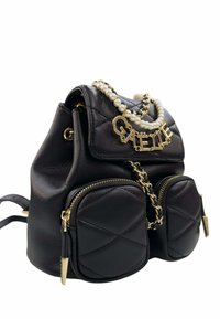 Zaino in pelle trapuntata nera con due tasche frontali con zip, manico in catena dorata e perle, e lettere dorate che formano la scritta "GAËLLE" sulla patta.