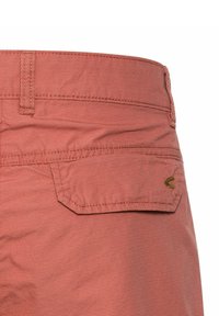 Rosa, strukturierte Shorts mit einer Gesäßtasche und diagonaler Klappe sowie genähten Details. Dezent eingestanztes Logo über der Tasche.