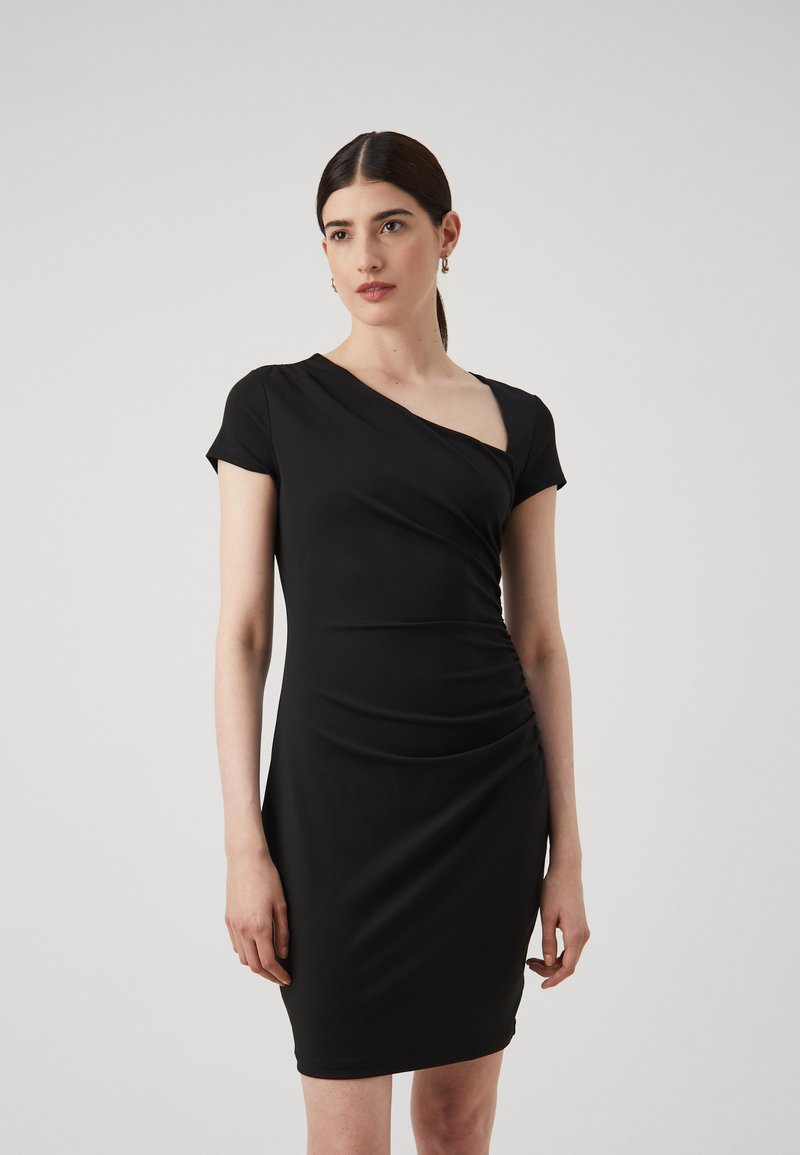 Robe noire ajustée avec des manches courtes, encolure asymétrique et texture froncée d'un côté. Tissu lisse et extensible.