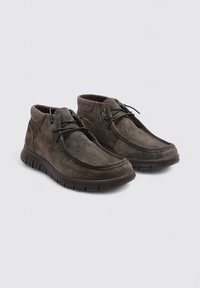 Bottines en suède marron foncé avec un col texturé marron, un laçage et une semelle en caoutchouc flexible avec des motifs en grille.