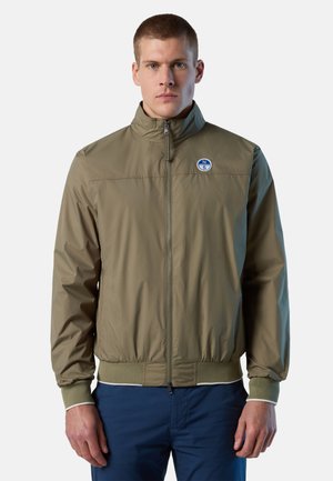 Giacca bomber leggera verde oliva con colletto alto, zip frontale, polsini a costine, patch logo sul petto e orlo elastico.