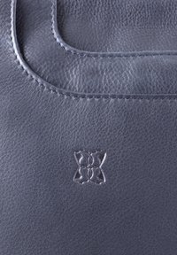 Leather bag with a soft, textured surface in dark gray. Features a subtle embossed logo and contrasting stitching along the edges.