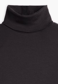 Haut col roulé côtelé en gris foncé. Présente un col haut et un tissu texturé avec des rayures verticales. Ajusté et confortable.