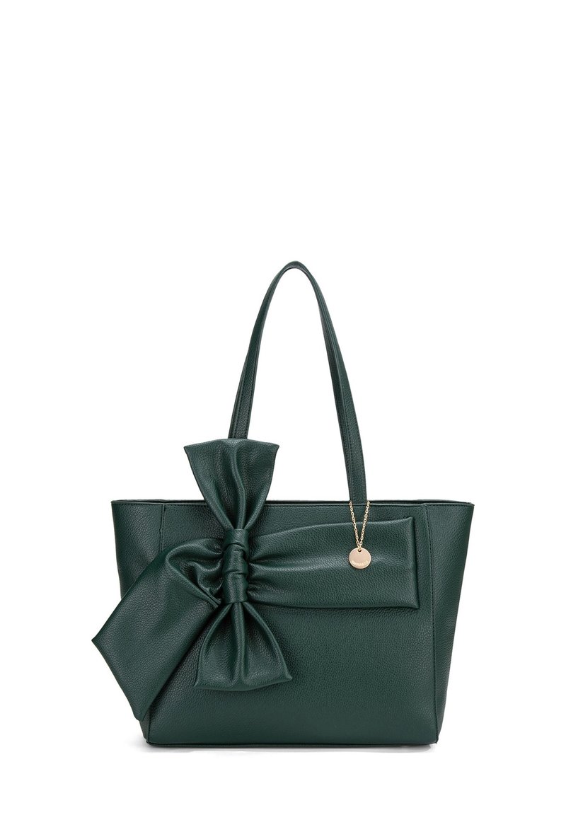 Borsa a spalla in pelle verde con un grande fiocco sulla parte anteriore, due manici e un ciondolo dorato, caratterizzata da una superficie texture e una forma rettangolare.