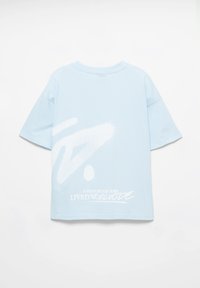 Ljusblå bomulls-t-shirt med korta ärmar. Har stor vit grafisk text och abstrakt design på baksidan, rund halsringning och avslappnad passform.