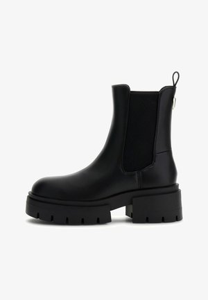 Bottines Chelsea noires avec une semelle épaisse, des panneaux latéraux élastiques et une languette. Fini en cuir lisse avec un design à bout rond.