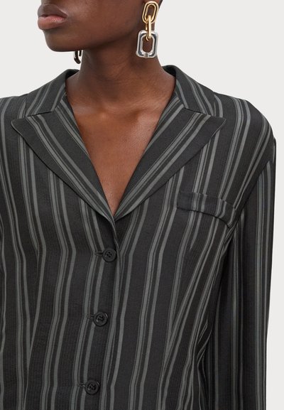 Black and gray striped shirt with a notched collar, five buttons, and a chest pocket. Features smooth fabric and long sleeves.