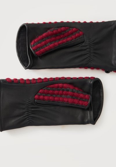 Paire de gants en cuir noir avec des détails rayés en laine rouge et cuir noir sur le dos, et une bordure en laine rouge le long des bords.