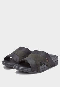 Svarta och grå slidessandaler med öppen tå, tillverkade av mocka och syntetiska material, med korsklingor och en strukturerad sula.