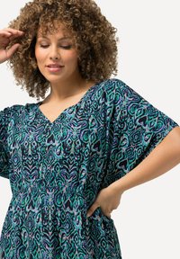 Fließendes schwarzes Kleid mit buntem abstrakten Muster. Hat einen V-Ausschnitt, weite Ärmel und einen elastischen Bund für Komfort.