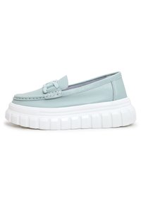 Světle modrá kožená slip-on obuv s tkaným detailem, která má silnou bílou platformovou podrážku s texturovaným povrchem.
