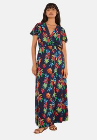 Robe maxi florale en navy, avec des manches courtes, un design portefeuille, une taille élastique et des motifs éclatants rouges, verts et bleus.