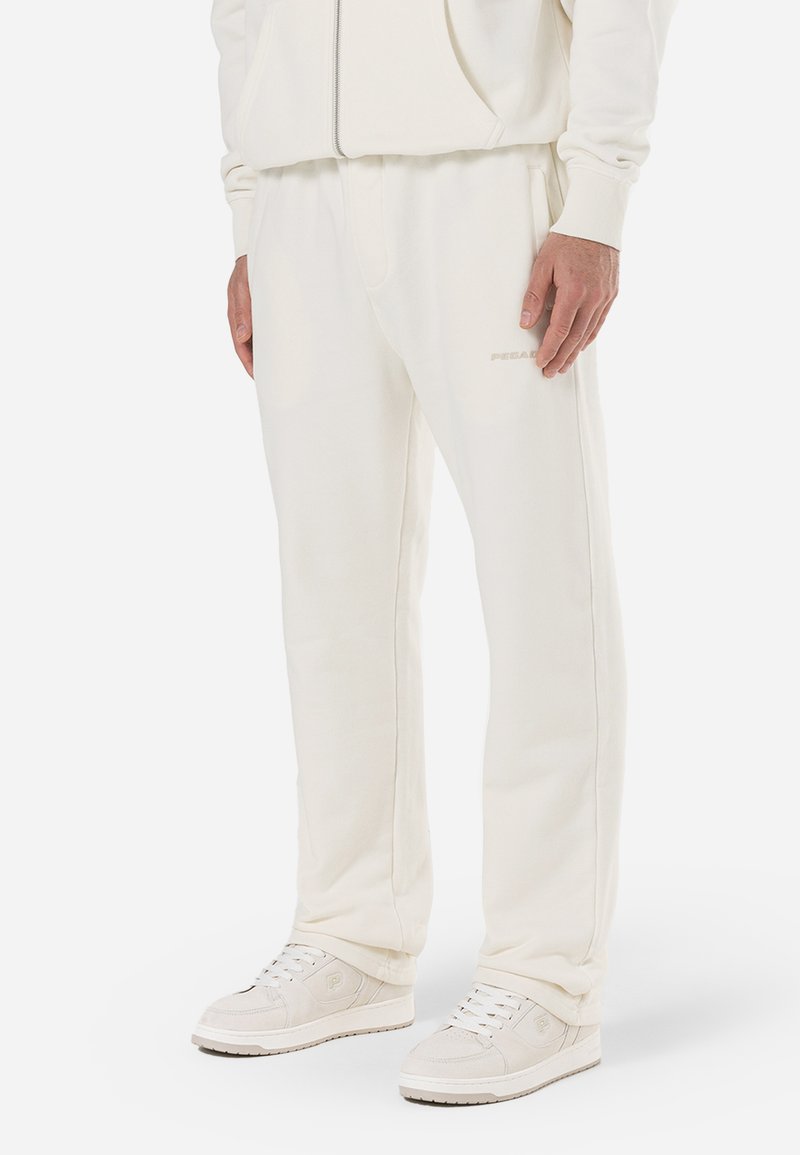 Pantalon de jogging en polaire blanche avec une taille élastique, des poches latérales et un discret logo. Texture lisse, coupe décontractée et jambes droites.