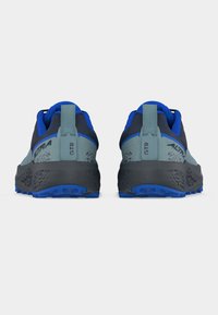 Ζευγάρι μπλε και γκρι παπούτσια για τρέξιμο μονοπατιού με ετικέτα "GTR" στην πίσω γλώσσα, βλέποντας από πίσω σε λευκό φόντο.